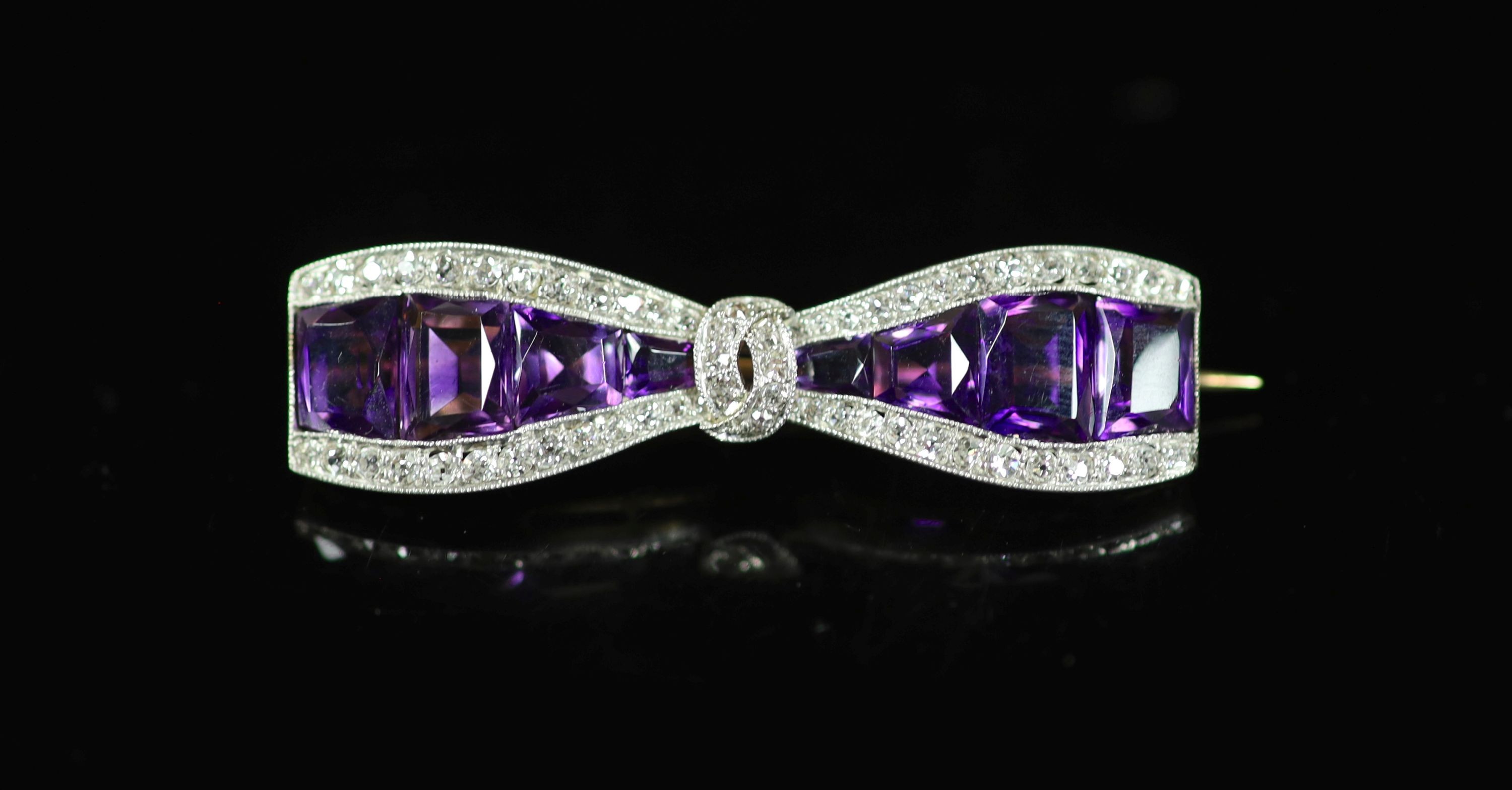 A 20th century gold and platinum, amethyst and millegrain diamond set 'bow tie' brooch